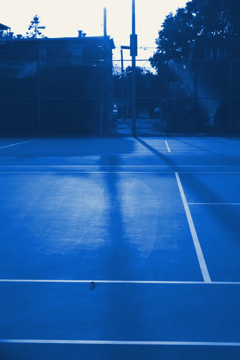 An empty tennis court in warm evening light
